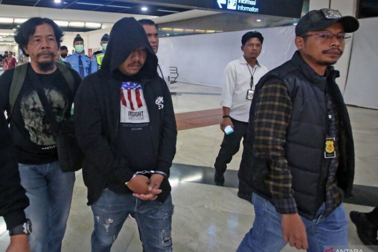 Anggota polisi Resmob Polda Metro Jaya membawa Lesly Watimena (tengah), debt collector pelaku pemaki petugas kepolisian, setibanya dari Ambon di Terminal 2 Bandara Soekarno Hatta, Tangerang, Banten, Kamis (23/2) lalu. (f: jp)