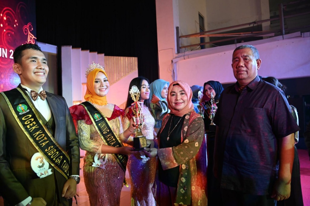 Foto: RIDWAN BUTARBUTAR/NEW TAPANULI Ketua TP. PKK Kota Sibolga Hj. Farida Hanum Siregar saat menyerahkan trophy kepada pemenang Ogek dan Uning Kota Sibolga Tahun 2023, Minggu (19/3/2023).