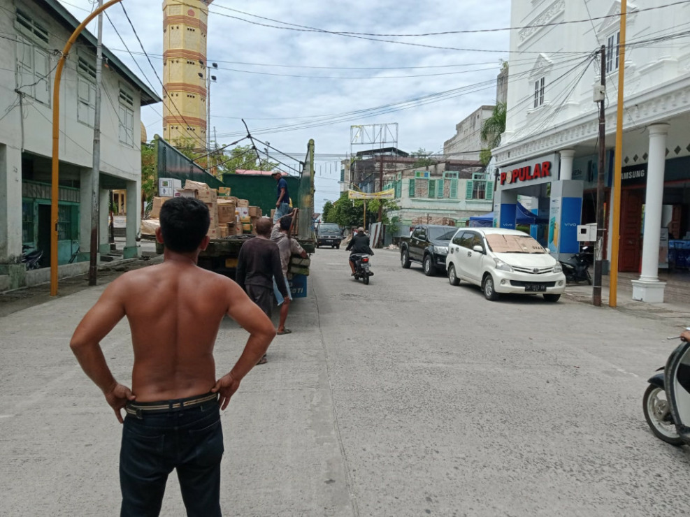 Satu unit truk membongkar muatan di tengah badan jalan Kota Sibolga.