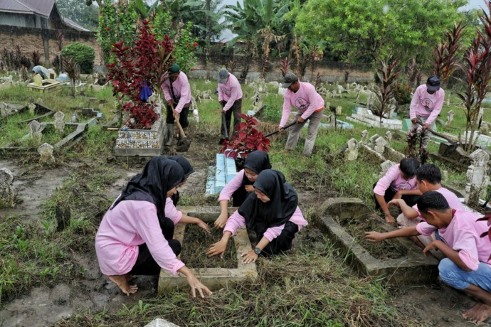 SEMANGAT: Ikatan Remaja Masjid Desa Sugiharjo, Kec. Batangkuis, Deli Serdang tampak semangat dalam aksi sosial bersih-bersih makam di wilayah tersebut, Minggu (5/3/2023). IST