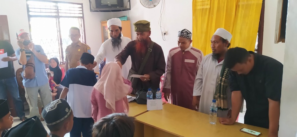 Pengurus Kotak Infaq pasar Gelugur Rantauprapat saat menyerahkan santunan kepada anak-anak yatim piatu di Kantor Kelurahan Sigambal. (Foto: Budi/MetroDaily)