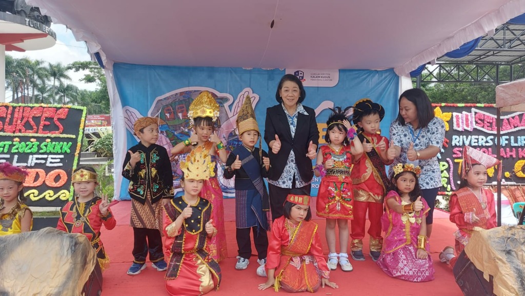 1.	Direktur Pelaksana Sekolah Kristen Kalam Kudus Pematang Siantar, Paulina Oscar, foto bersama para siswa TK, di sela-sela atraksi seni para siswa di Lapangan Pariwisata Kota Pematang Siantar, Sumatera Utara, Sabtu (27/5/2023). (Foto: Dame Ambarita/Metro