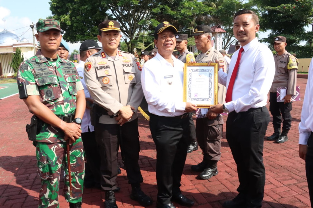 Bupati Simalungun Radiapoh Hasiholan Sinaga (RHS) didampingi Kapolres Simalungun AKBP Ronald FC Sipayung dan Dandim 0207/Simalungun Letkol Inf Hadrianus Yossy menyerahkan piagam penghargaan, di halaman Mapolres Simalungun, Pamatang Raya. (f: Polres Simalu