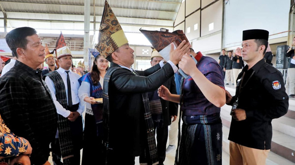 Ketua KPU Simalungun Raja Ahab Damanik menyematkan gotong Simalungun kepada Ketua Komisi II DPR RI disaksikan Bupati Simalungun Radiapoh Hasiholan Sinaga dan Ketua DPRD Simalungun.