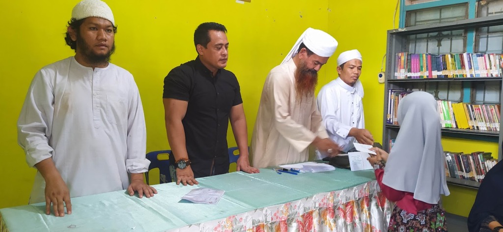 Pengurus kotak infaq Pasar Gelugur Rantauprapat saat memberikan santunan kepada anak-anak yatim piatu disaksikan oleh Lurah Sirandorung Muhammad Rizal Rambe. (Foto: Budi/MetroDaily)