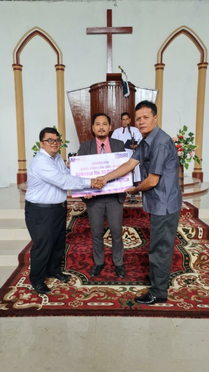 Ketua PKK BRI BRI Cabang Sibolga, Richard Julius Purba dan pihak HKBP Sigotom foto bersama usai penyerahan bantuan, Minggu (23/7/2023). (Foto: Dok BRI Sibolga)