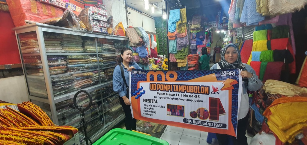 BERSAMA: Seorang pegawai BRI bersama pedagang ulos di Pusat Pasar Medan, Selasa (8/8/2023), dalam program Gerebek Pasar. IST