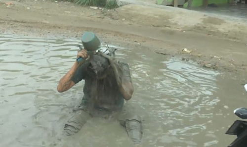 Tuah Hariadi warga Desa Silo Baru, Kecamatan Silau Laut Kabupaten Asahan yang viral karena mandi air berlumpur di kubangan jalan rusak.
