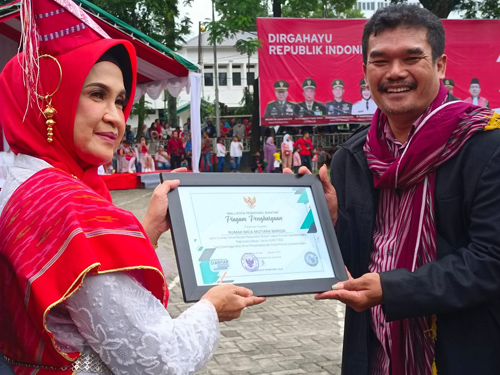 Penyerahan penghargaan kepada pemilik Rumah Baca Mutiara Bangsa Tagor Leo Sitohang.