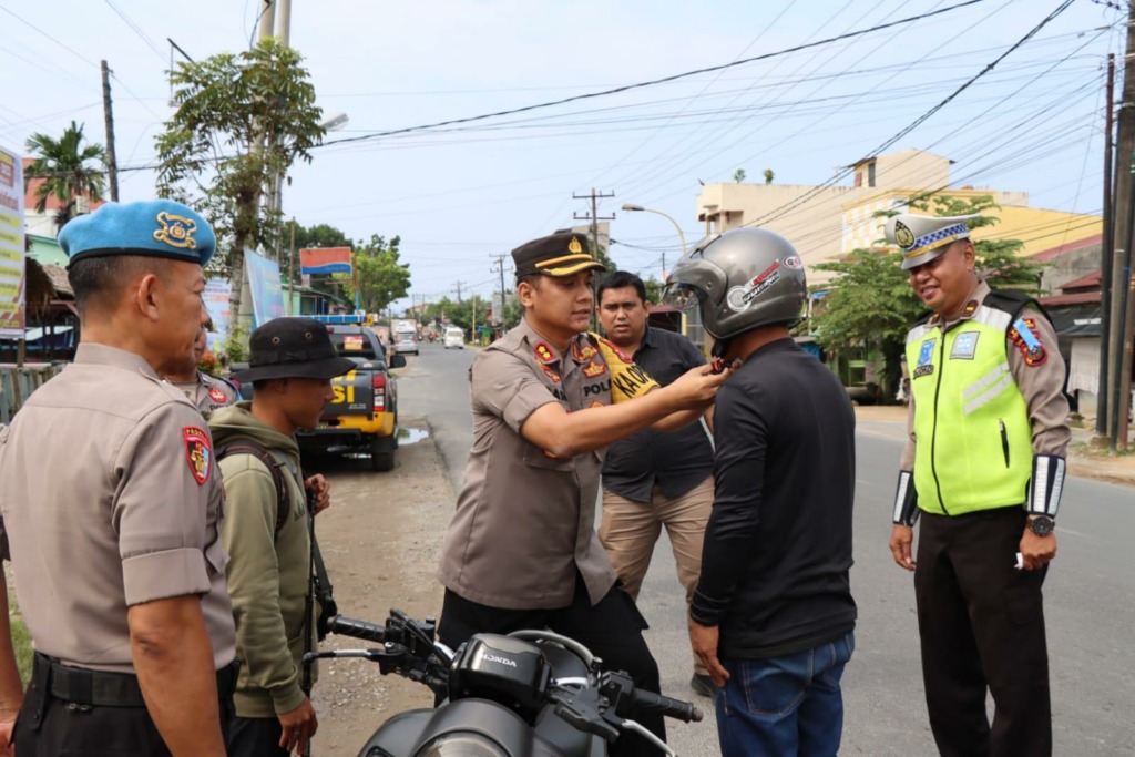 Kapolres Tapteng, AKBP Basa Emden Banjarnahor saat membagikan helm gratis kepada para pengendara yang tidak menggunakan helm.