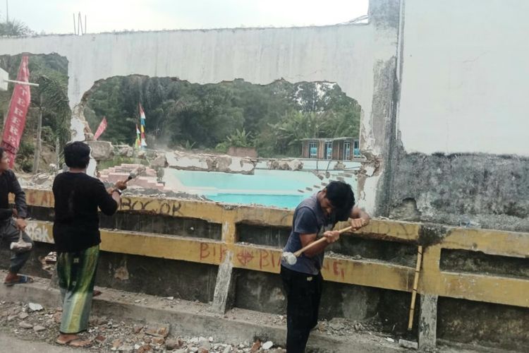 Warga merobohkan tembok penghalang jalan yang letaknya persis di tikungan jalan menanjak berlokasi di Sidomulyo, Kelurahan Simarimbun, Kecamatan Siantar Marimbun, Kota Siantar. (f: metro/kdc)