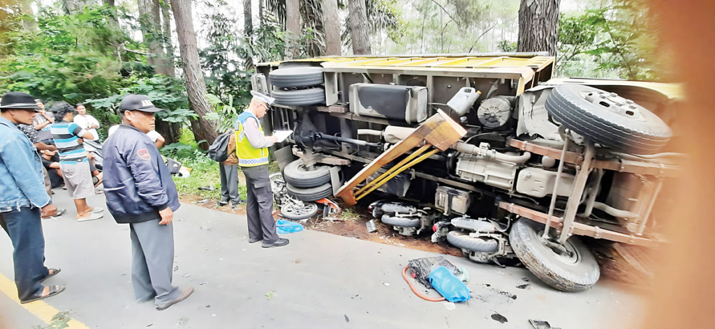 Truk yang menimpa sepedamotor. 