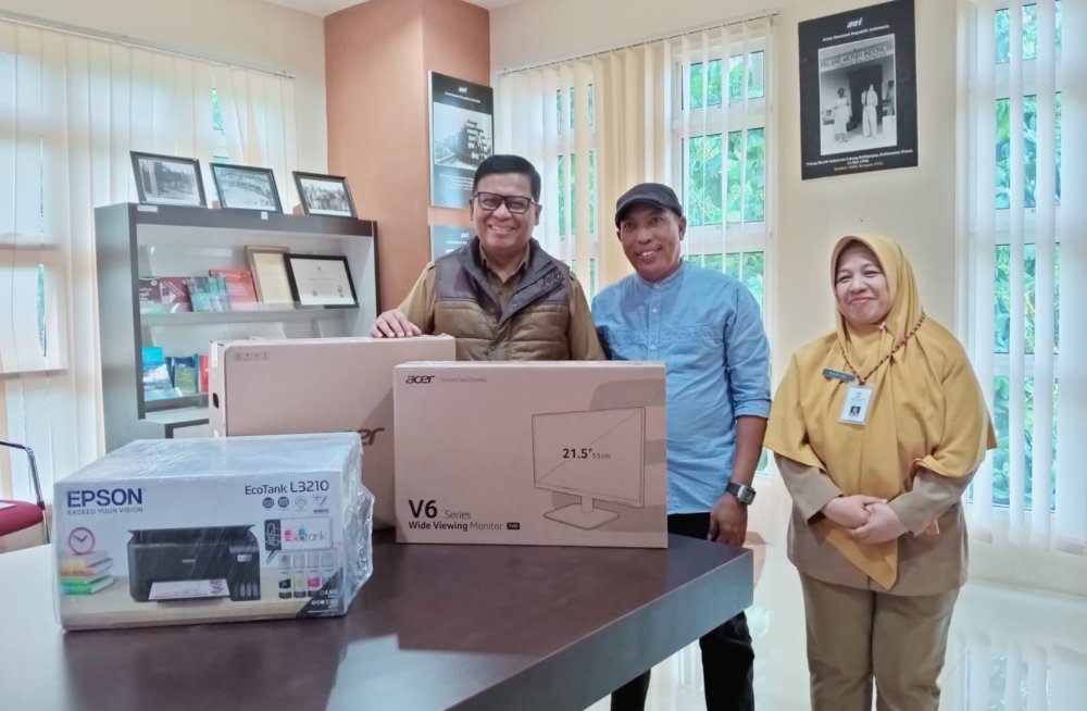 Ketua Perpustakaan Cahaya Ilmu Kelurahan Margasari Abdal (baju biru) menerima bantuan komputer dan printer dari Dinas Perpustakaan dan Arsip Daerah Kota Balikpapan.