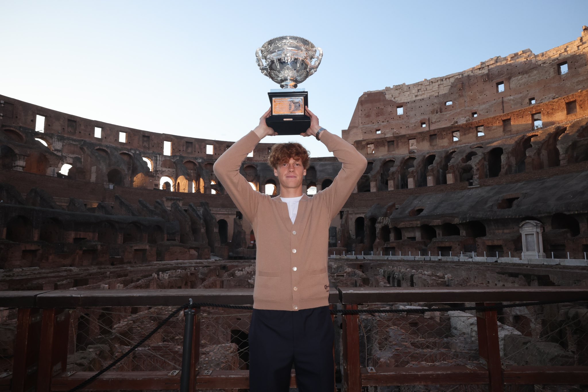 Jannik Sinner berpose dengan Norman Brookes Challenge Cup (trofi grand slam Australia Terbuka) di Colosseum, Roma, Italia, Rabu (31/1/2023).