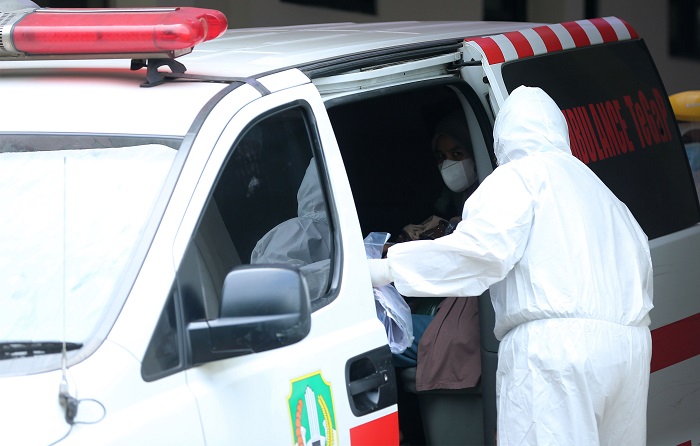 Petugas mengevakuasi  pasien Covid-19 memasuki mobil ambulans untuk dipindahkan ke  rumah sakit di Jawa Barat.