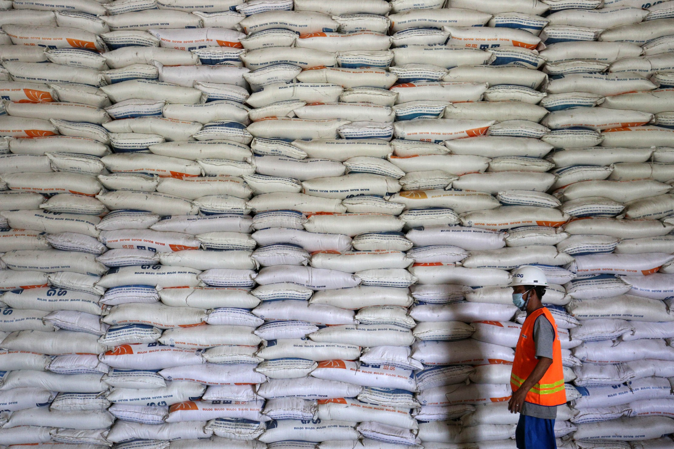 Pekerja menata karung berisi beras di Gudang Bulog Kanwil DKI dan Banten, Kelapa Gading, Jakarta, Kamis (18/3/2021). Perum Bulog memprioritaskan pengadaan beras dari produksi dalam negeri dengan target 500.000 ton dalam tiga bulan ke depan.FOTO:MIFTAHULHA