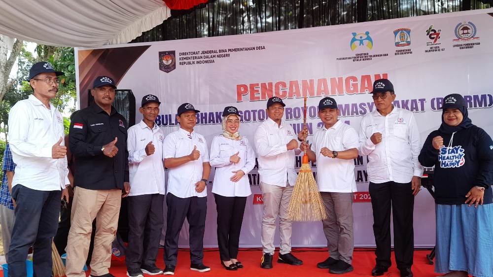 Asisten 1 Tata Pemerintahan Zulkipli, didampingi Kepala DP3AKB dan ketua DPD LPM Kota Balikpapan menyerahkan simbolis alat-alat kerjabakti dalam pencanangan BBGRM tahun 2024 di Kota Balikpapan.