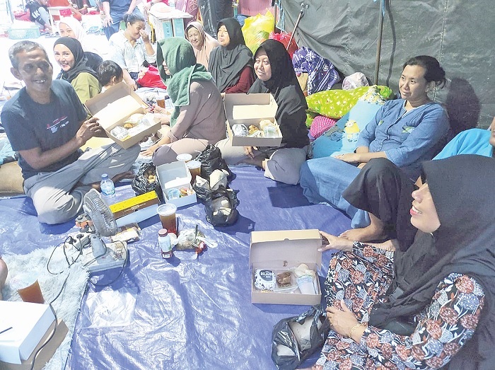 Musri dan keluarga korban kebakaran menanti waktu berbuka puasa di tenda pengungsian korban kebakaran di Klandasan Ulu, Balikpapan Kota, Rabu (20/3).