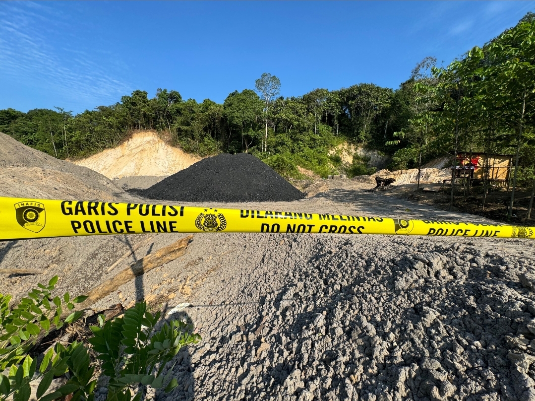 BUKTI KEJAHATAN: Jalan masuk ke lokasi tumpukan batu bara di RT 38, Kelurahan Lempake, Kecamatan Samarinda Utara, dipasangi garis polisi, terlihat barang bukti dugaan tambang ilegal ditinggalkan.
