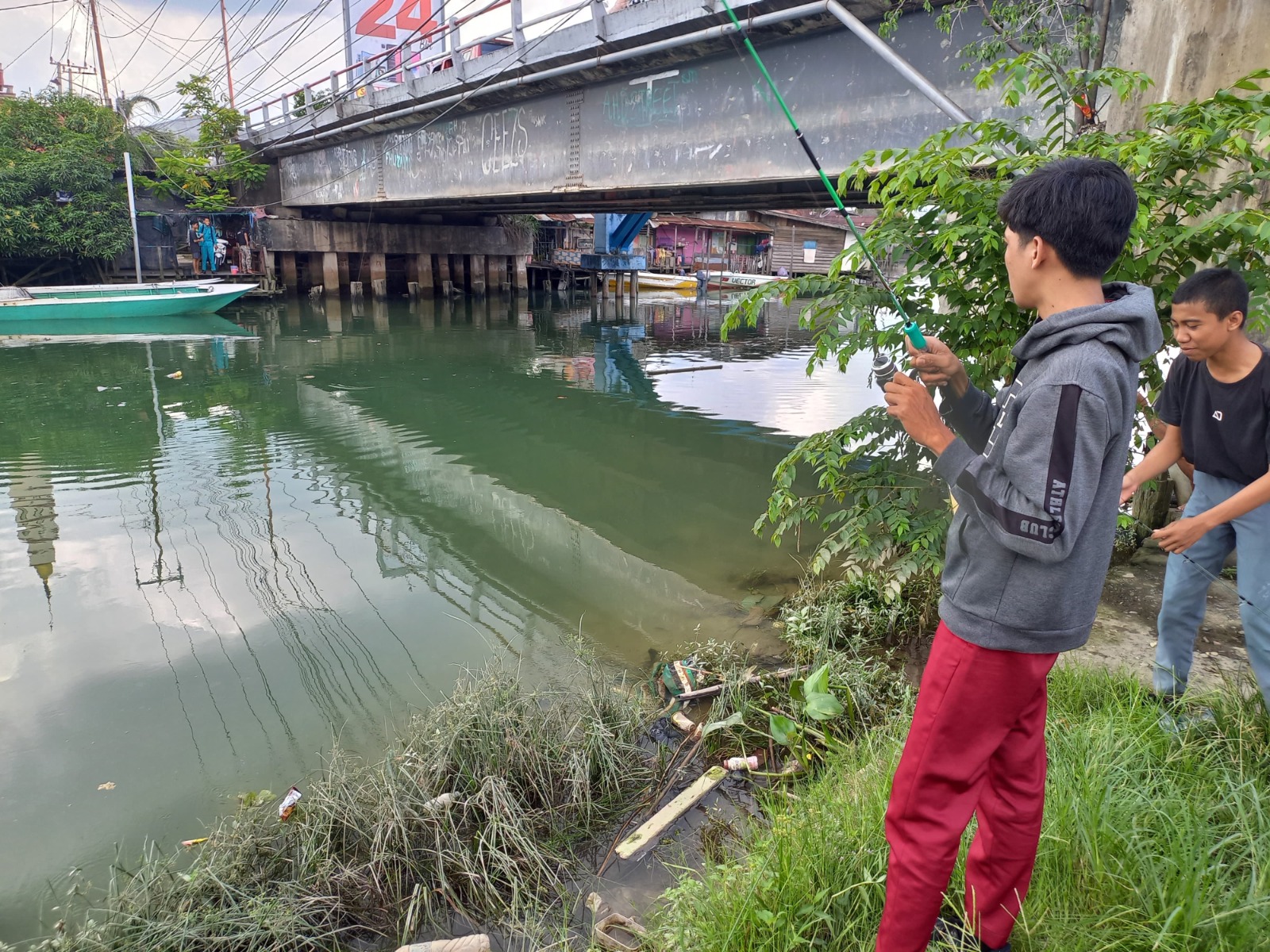 BERUBAH: Sungai Karang Mumus di kawasan Jalan Tarmidi, Kecamatan Samarinda Kota, tiba-tiba jadi spot mancing dadakan. Disebabkan perubahan warna sungai dari cokelat ke hijau dan ikan-ikan bermunculan.