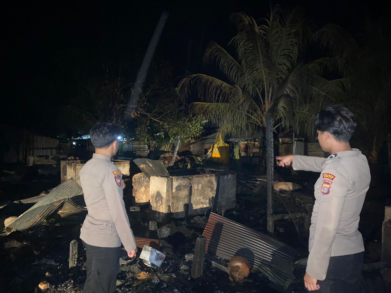 TINGGAL PUING : Polisi saat menunjukan mes yang ditinggali karyawan perusahaan kelapa sawit dan sudah rata dengan tanah.