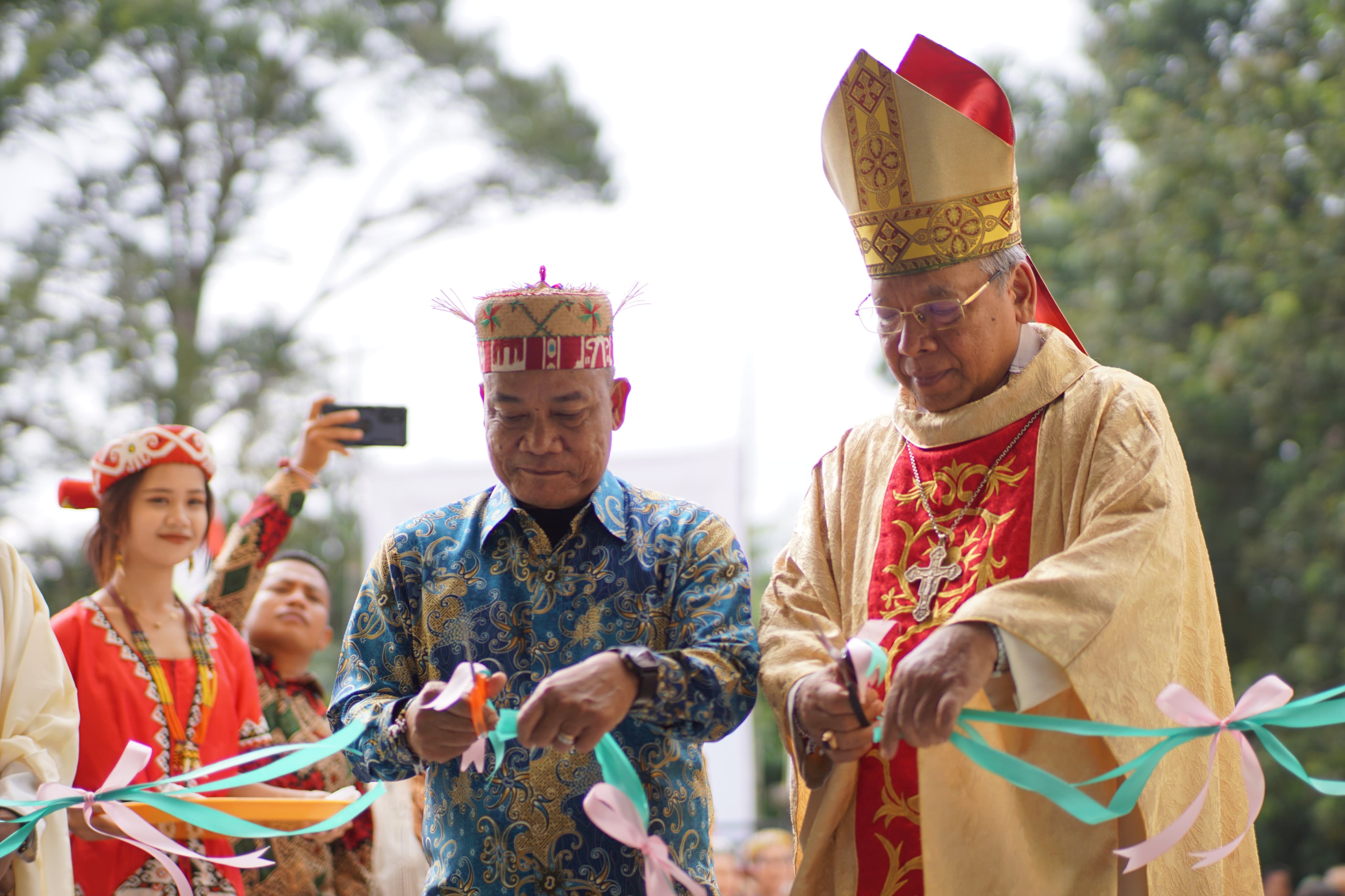AKHIRNYA SELESAI: Wakil Bupati Yohanes Avun dan Uskup Agung Mgr Yustinus Harjosusanto memotong pita simbolik resminya Gereja Santo Christianus, Sabtu (6/7). (FOTO: JODI)