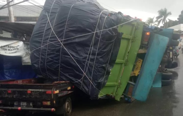 NAHAS: Truk yang muatannya melebihi kapasitas menimpa mobil. (foto: Ist)