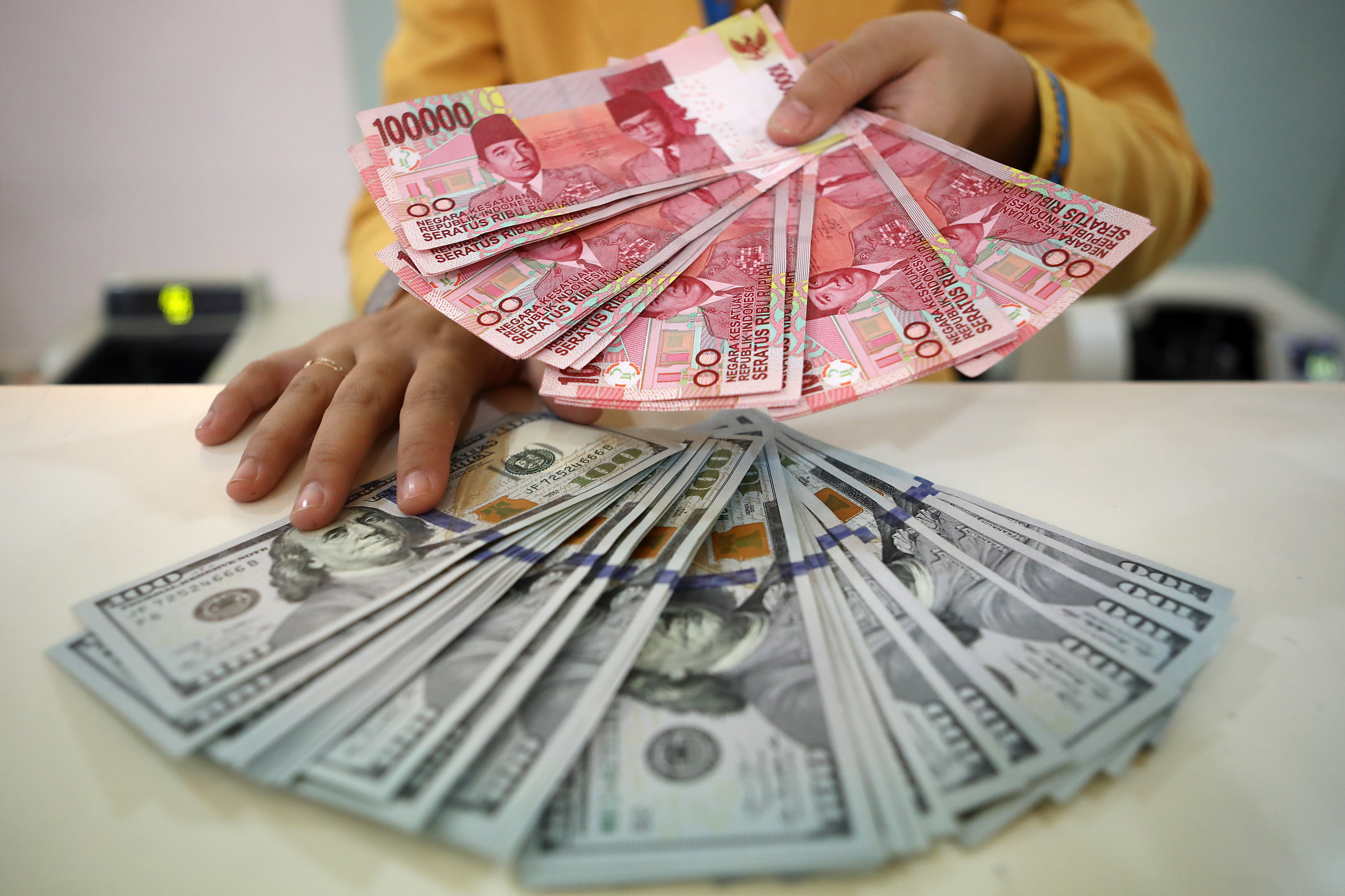 Teller menunjukkan mata uang rupiah dan dollar di Bank Mandiri KCP Senayan, Jakarta. FOTO: HENDRA EKA/JAWA POS