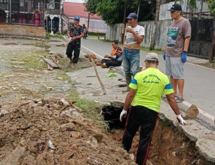 Warga RT 8, Kelurahan Api-Api melakukan kerja bakti memperbaiki sodetan drainase di depan Rumah Adat Lamin Dayak secara manual.