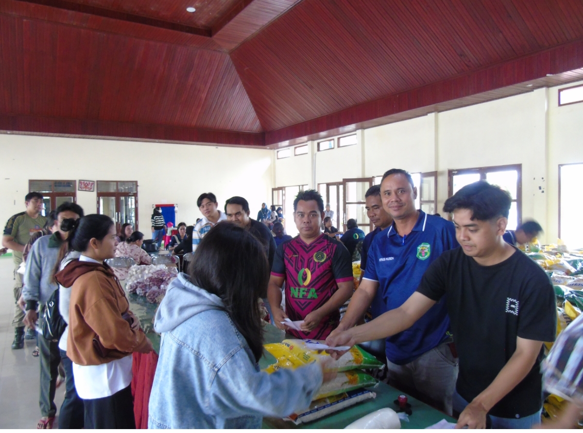 GPM SUKSES: Gerakan pangan murah sukses digelar, tampak Kabid Ketersediaan dan Distribusi Pangan Petrus Husen membantu melayani warga. (FOTO: SUNARDI/KP)