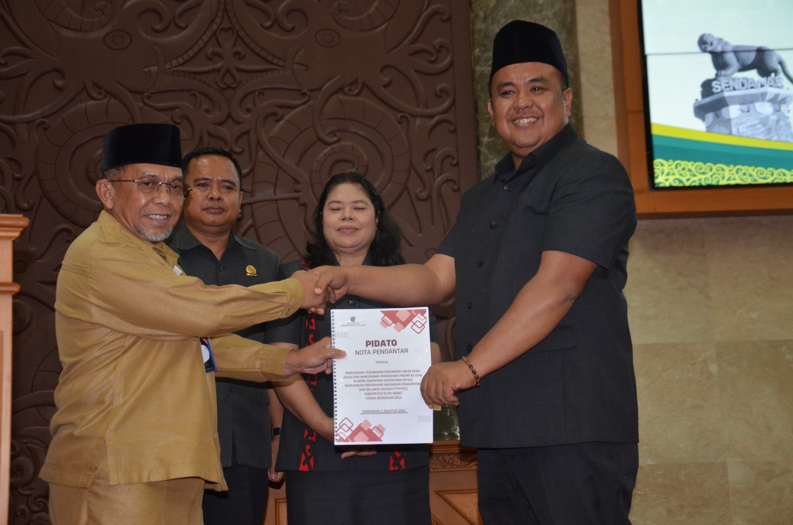 MENDUKUNG: Rakhmat (kiri) menyerahkan dokumen nota pengantar rancangan perubahan KUA dan Prioritas dan PPAS APBDP tahun anggaran 2024 kepada Wakil Ketua 2 DPRD Kubar Aula (kanan). (FOTO: IST)