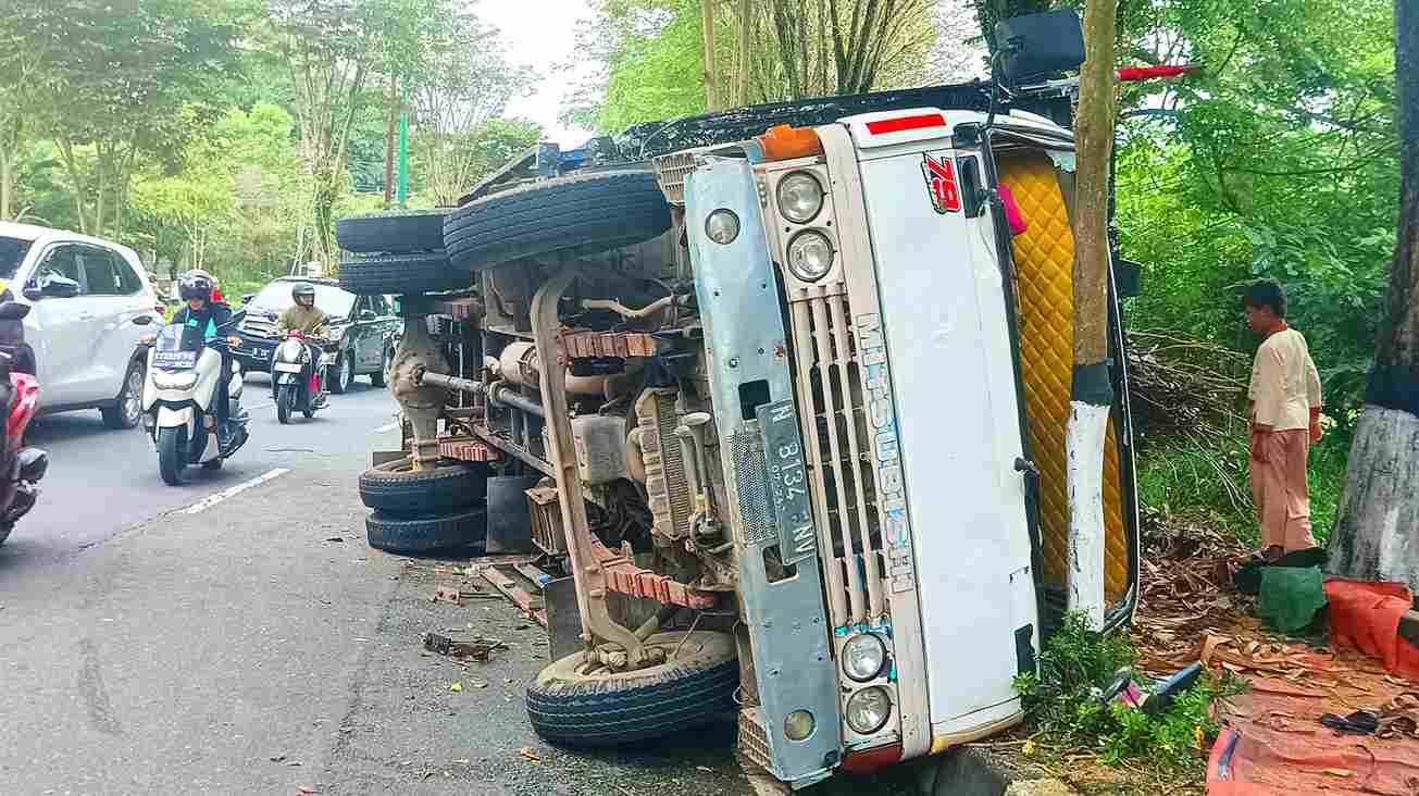TERBALIK: Kecelakaan tunggal truk bermuatan barang terbalik di pinggir jalan. (SYAHRUL/KP)