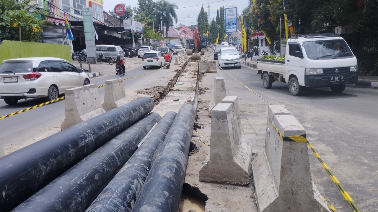 PROSES: Ekskavator membelah Jalan Bhayangkara untuk menanam pipa jaringan distribusi utama air bersih, menghubungkan IPA Tirta Kencana menuju reservoir Segiri di Jalan Pahlawan, Kamis (29/8).