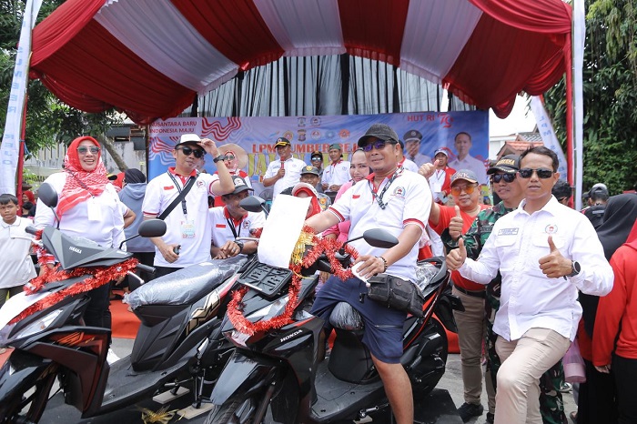 Ketua LPM Sumber Rejo Yudhie Eka Putra (kanan) didampingi Lurah Sumber Rejo Paing (tiga kanan) bersama warga Sumber Rejo yang beruntung mendapatkan hadiah utama sepeda motor.