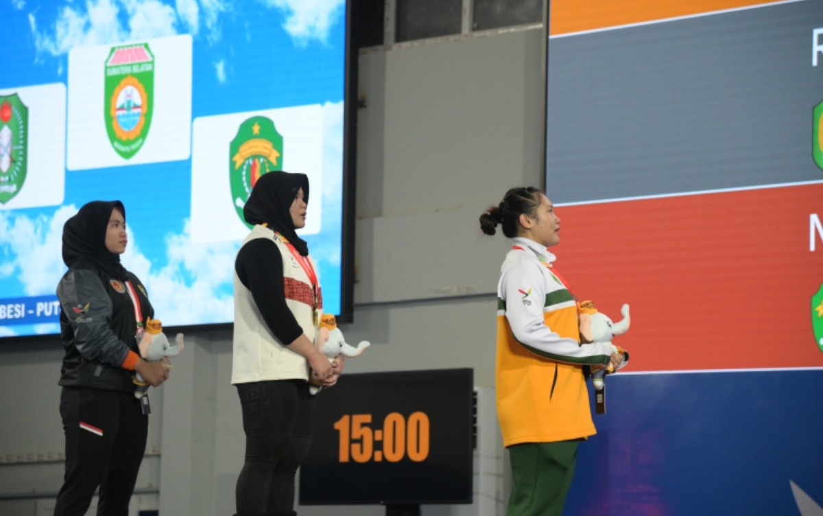 TETAP BERSYUKUR: Lifter Kaltim Nelly (kanan) berhasil menyumbangkan medali perunggu angkat besi kelas 71 kilogram putri.  (FOTO: DONI ADITYA HARYONO)