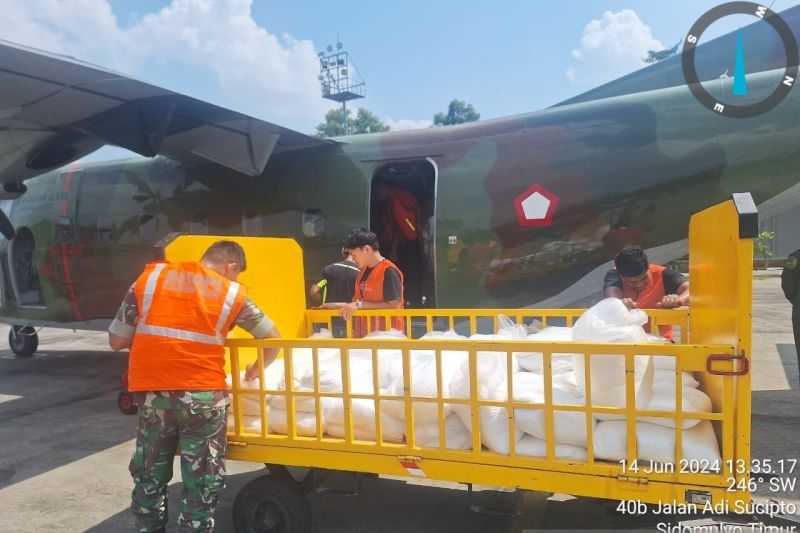 BANTAH: Personel TNI AU Lanud Sultan Syarif Kasim II mempersiapkan bahan Natrium Klorida/NaCl untuk operasi modifikasi cuaca menggunakan pesawat dari Skuadron Udara 4 Malang. (Foto: HO-BMKG)