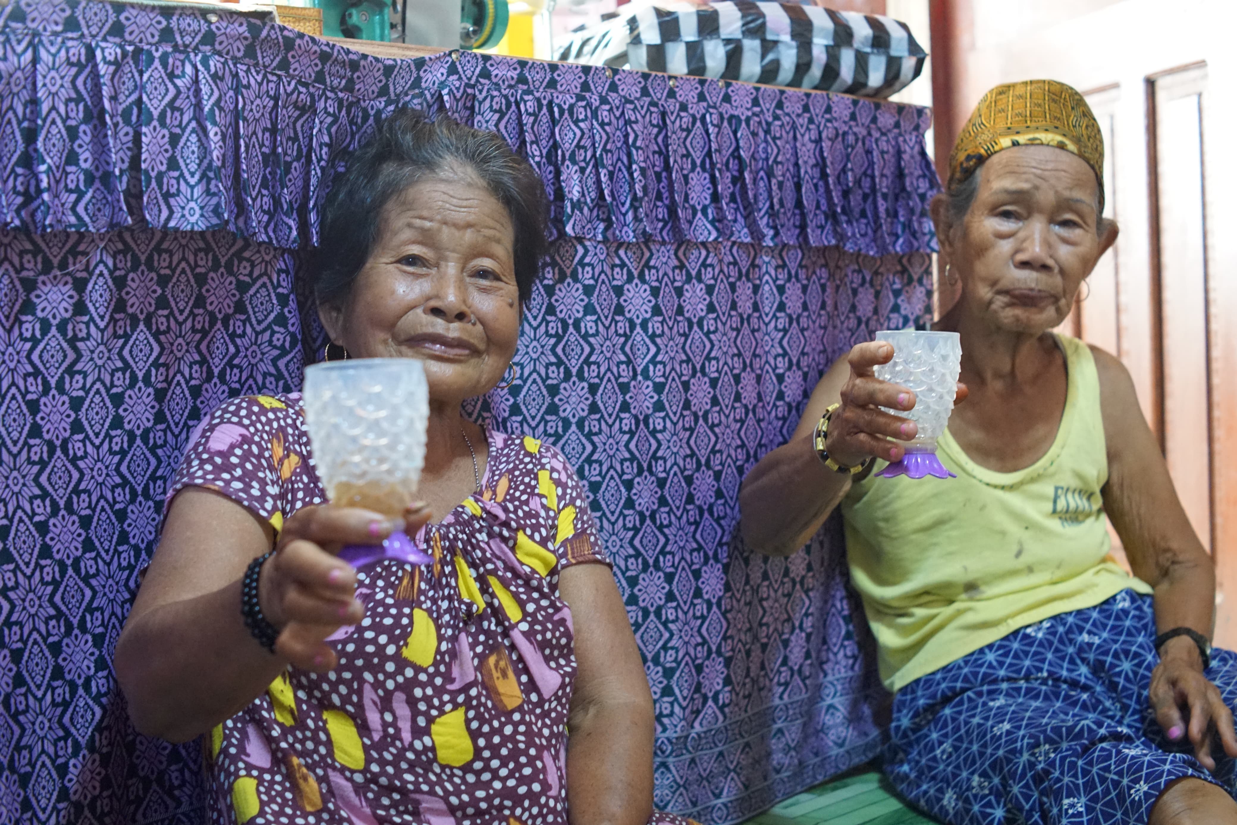 MINUMAN KHAS; Dua nenek paruh baya menikmati Burak sehabis bekerja di ladang. (Foto:Jody Kristianto)
