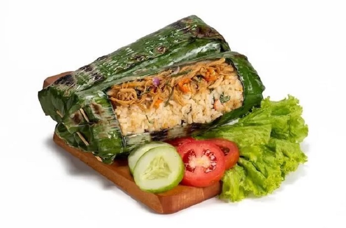 Nasi Bakar Ayam Kemangi menawarkan sensasi rasa yang unik karena nasi dibungkus dengan daun pisang dan dibakar hingga harum.