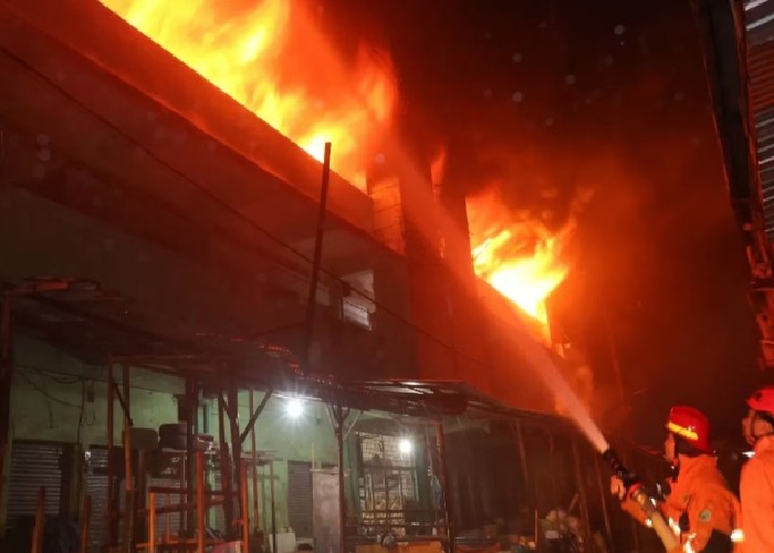Petugas pemadam kebakaran berusaha memadamkan api di Pasar Comboran, Malang, yang menghanguskan belasan mobil dan barang dagangan.