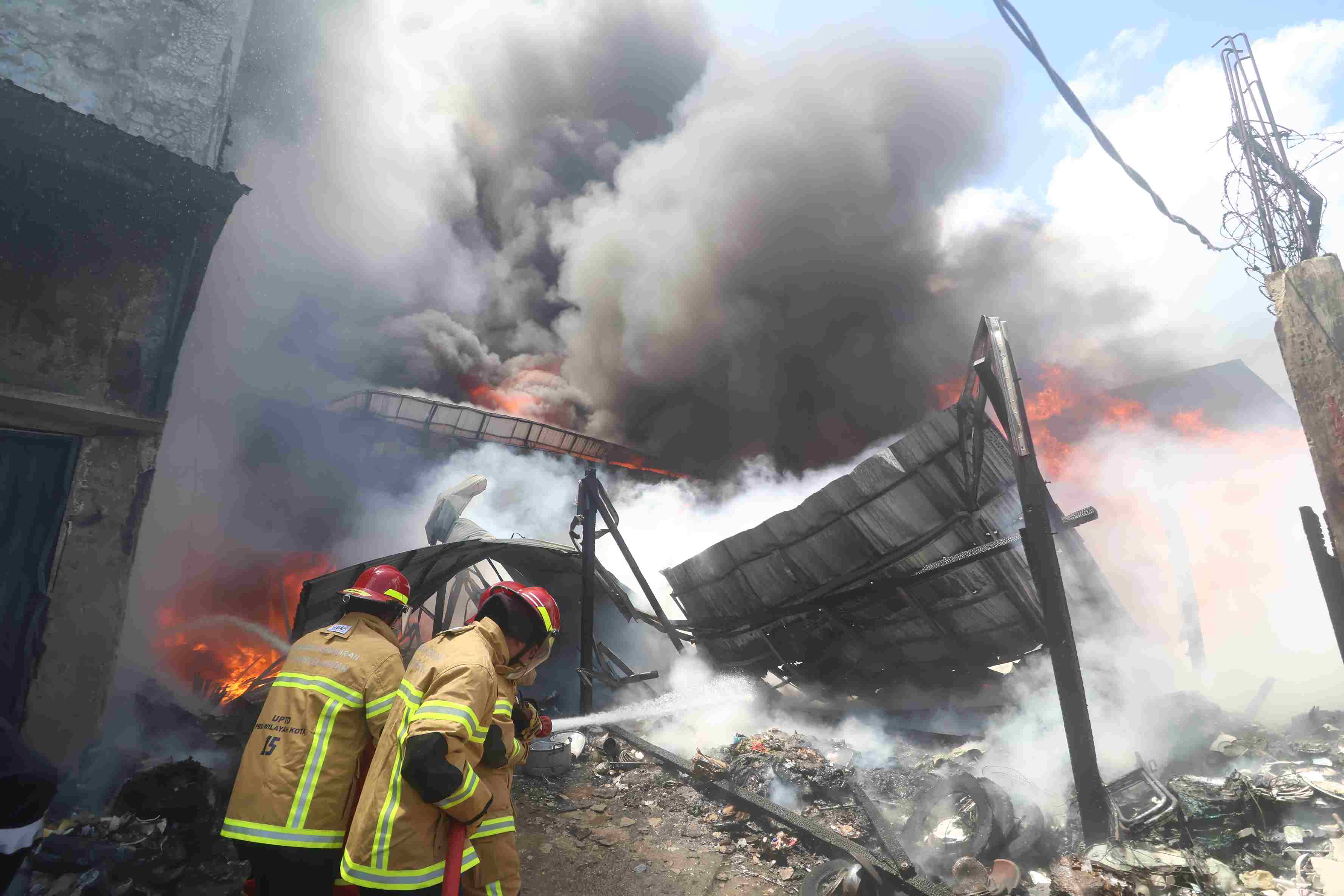 BERJIBABAKU: Petugas berusaha memadamkan api pada kebakaran gudang perabot di Balikpapan, Selasa (17/9). (Foto: Anggi/KP)