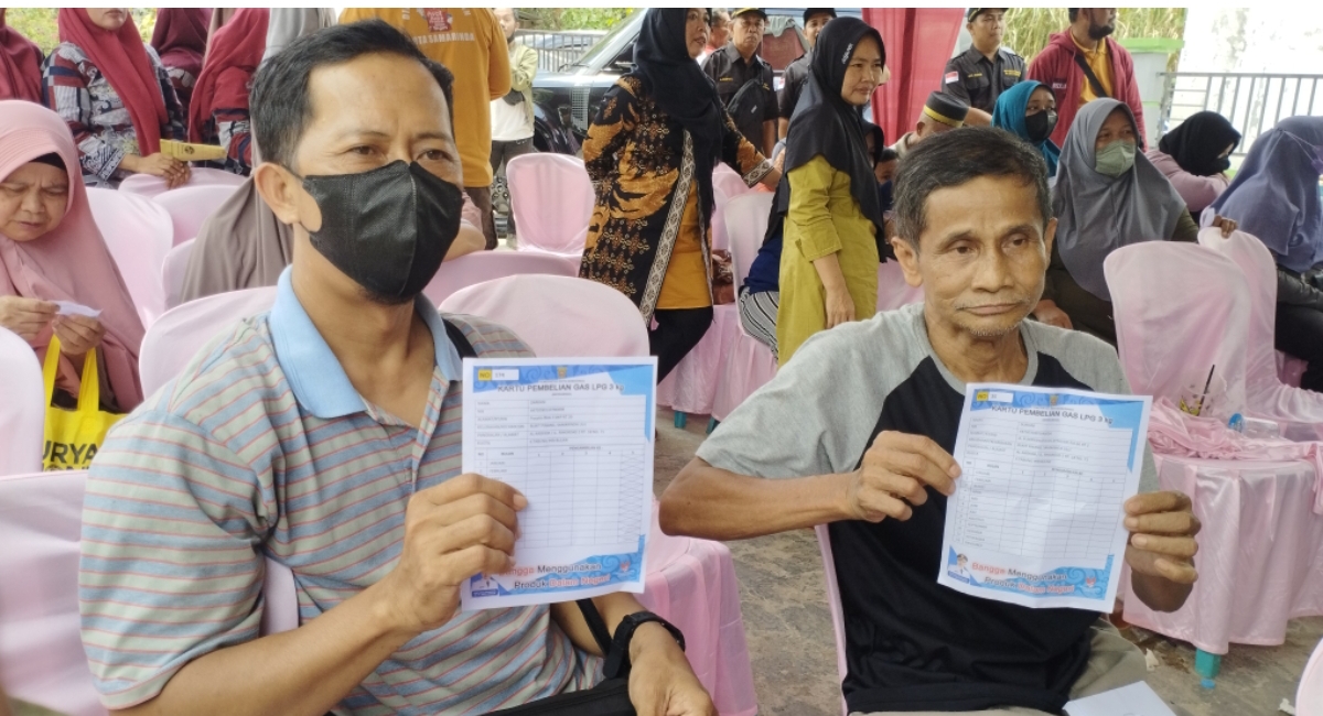 HARAPAN: Zarkani (kiri) dan Suriani menunjukkan kartu kendali pembelian tabung elpiji 3 kg yang dibagikan Pemkot Samarinda. (DENNY SAPUTRA/KALTIM POST)