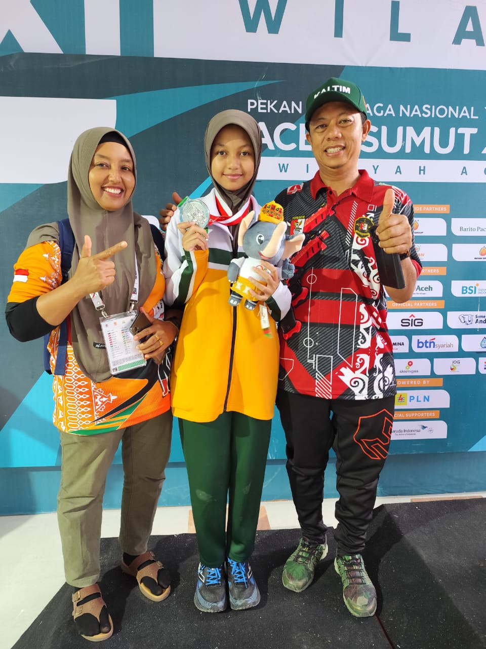 BERPRESTASI : Bersama ayah dan ibunya, Aretha memamerkan medali perak yang diraih di PON Aceh-Sumut. (Foto: Perbaikin)