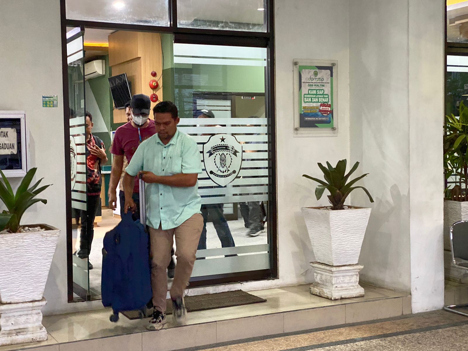 GELEDAH: Petugas KPK keluar membawa koper yang diduga berisi dokumen dari DPMTSP Kaltim. (Foto: Dwi Restu/KP)
