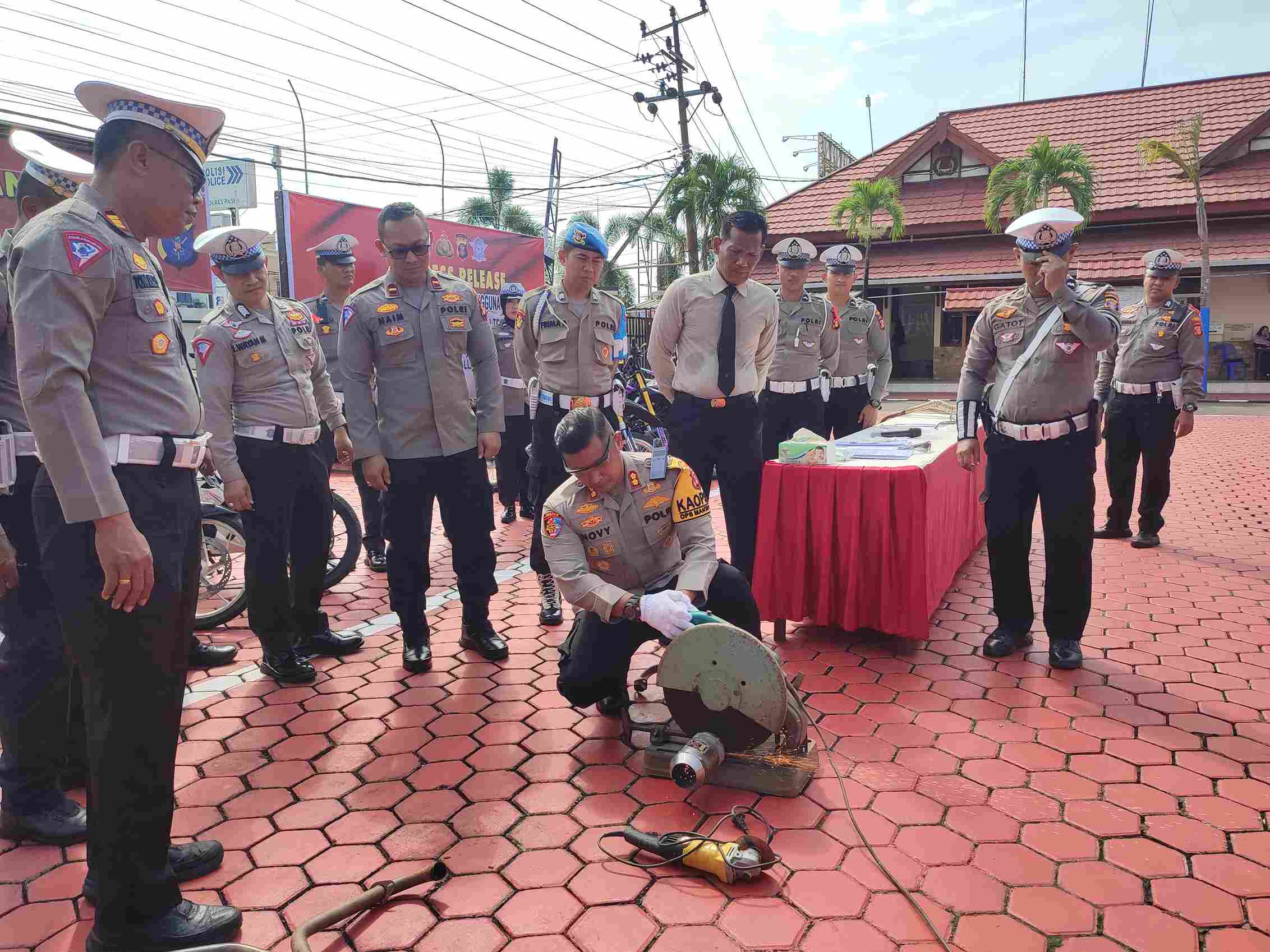 LANGSUNG DIPOTONG: Kapolres Paser AKBP Novy Adi Wibowo memotong knalpot yang tidak sesuai spesifikasi teknis kendaraan bermotor, Selasa (1/10/2024). (Foto: Najib/KP)