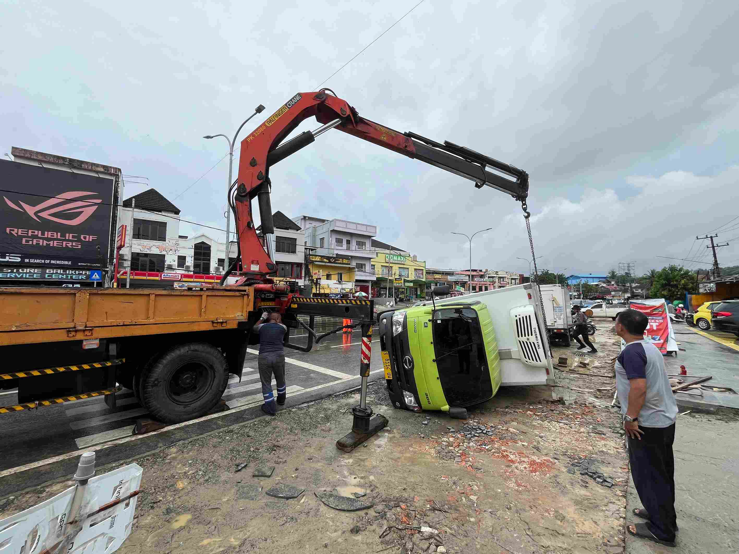 TERGULING: Sebuah truk yang rebah karena badan jalan yang amblas di Jalan MT Haryono Balikpapan pada Senin (30/9). (Foto: Anggi/KP)