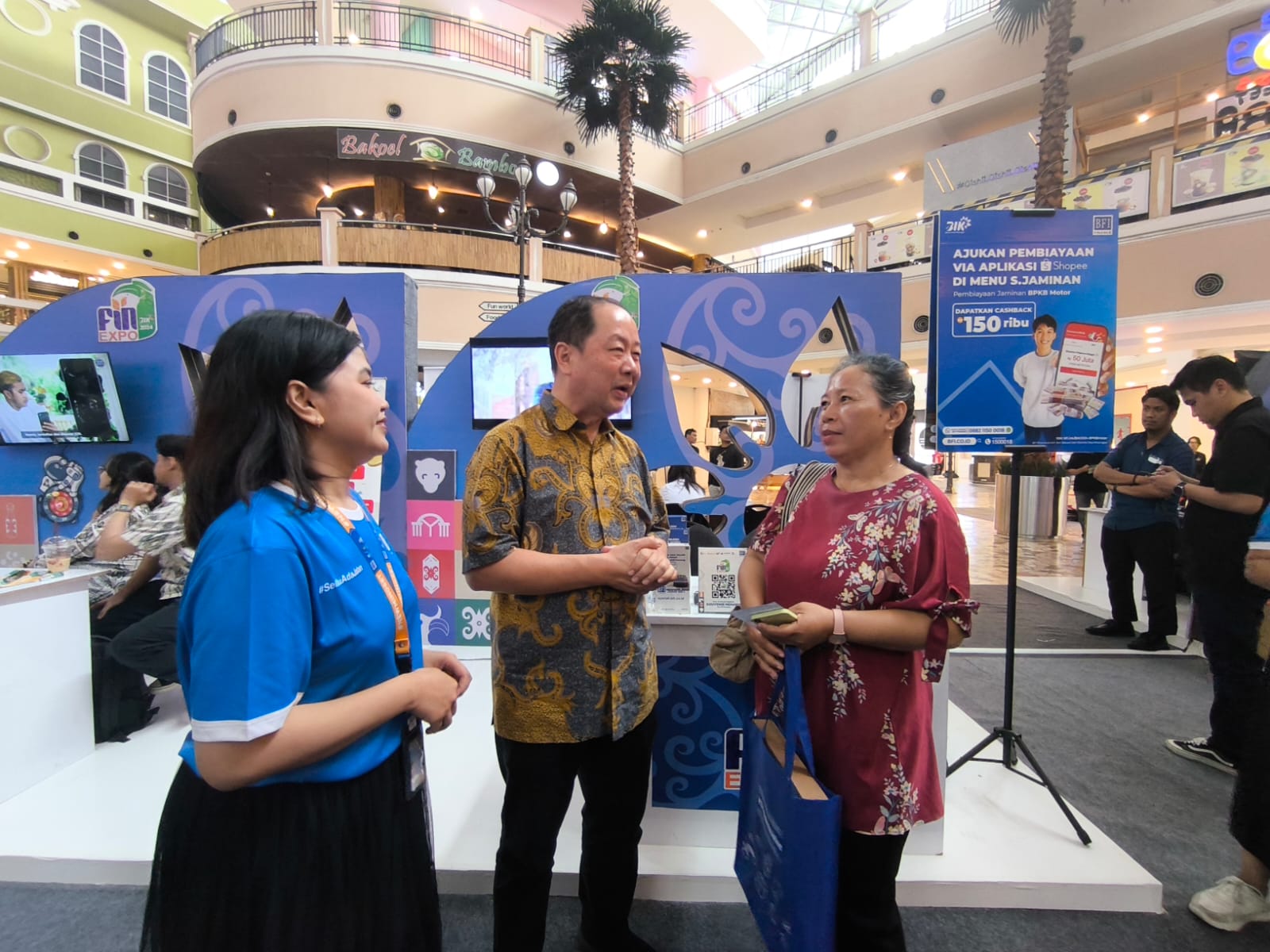 LEBIH DEKAT: General Manager BFI Finance Region Kalimantan 2 Hernandi Kusno (tengah) menyapa konsumen di booth BFI Finance dalam pameran BIK 2024 di e-Walk Balikpapan.(Foto: Ist)