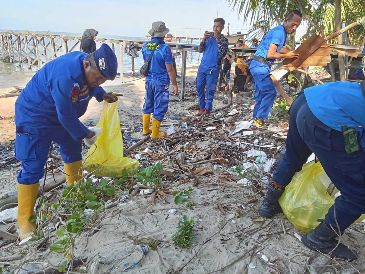 BERSIH PANTAI: Masyarakat dan personel Ditpolairud Polda Kaltim serta Polresta Balikpapan melakukan bersih-bersih sampah di Pantai Semayang. (foto:ist)