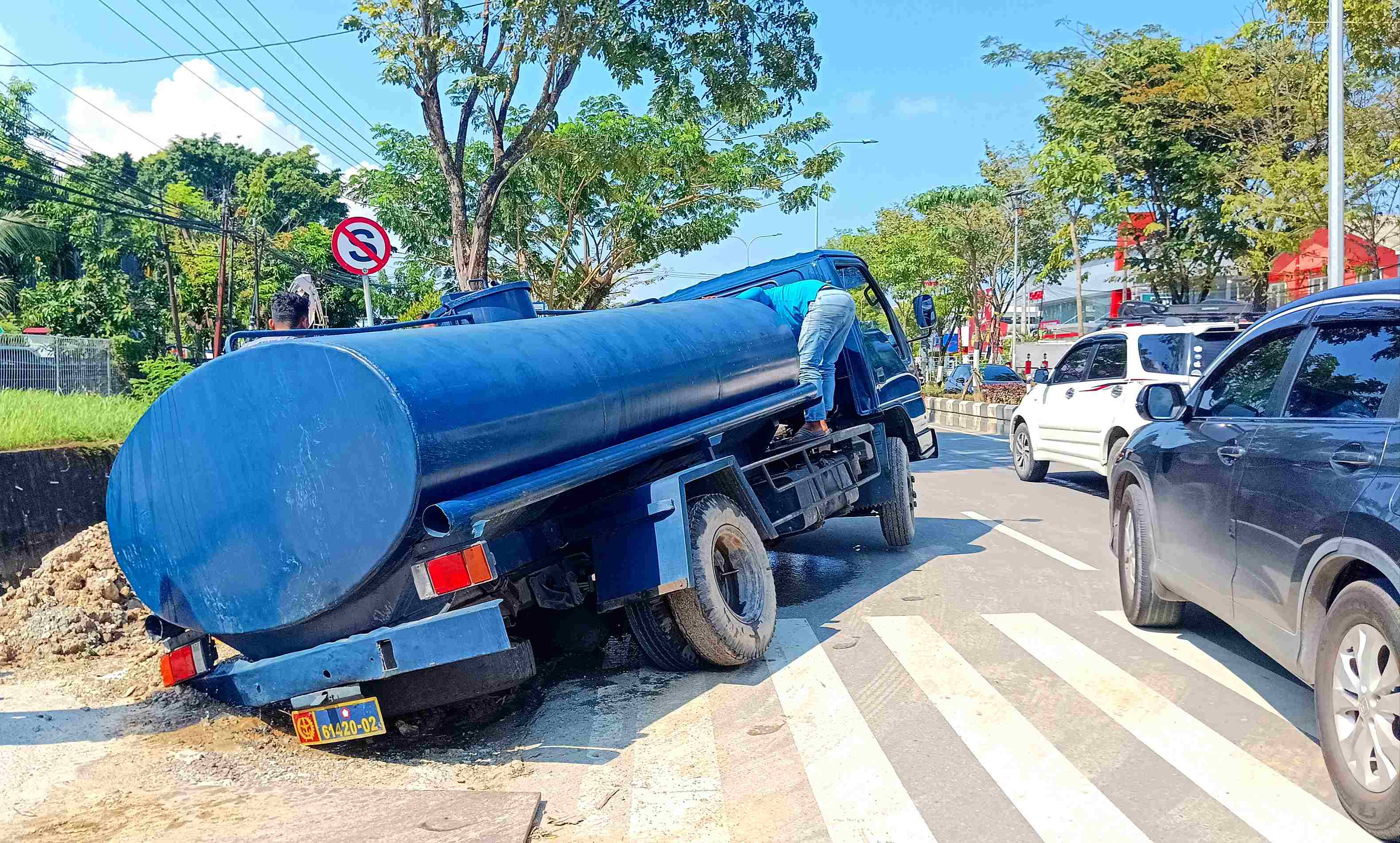 KORBAN LAGI: Truk tangki air dengan plat TNI amblas di Jalan MT Haryono.