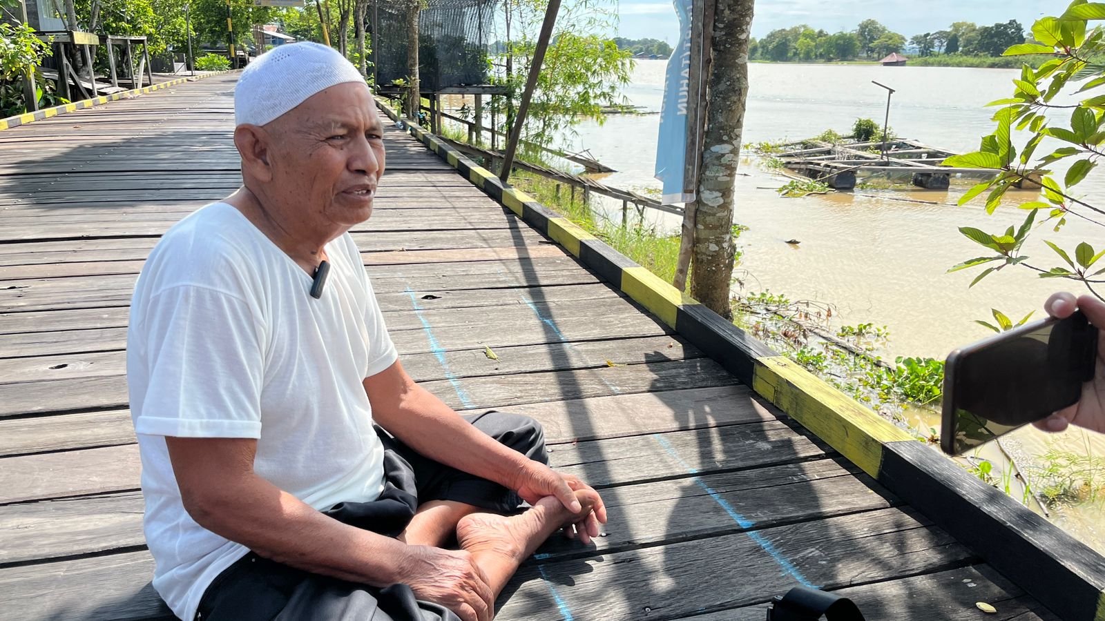 MENIKMATI HIDUP: Yusni menyempatkan berbincang dengan pengunjung yang menikmati wisata di Desa Pela, Kota Bangun, Kutai Kartanegara. Kini senang kampungnya terdengar sampai Eropa.