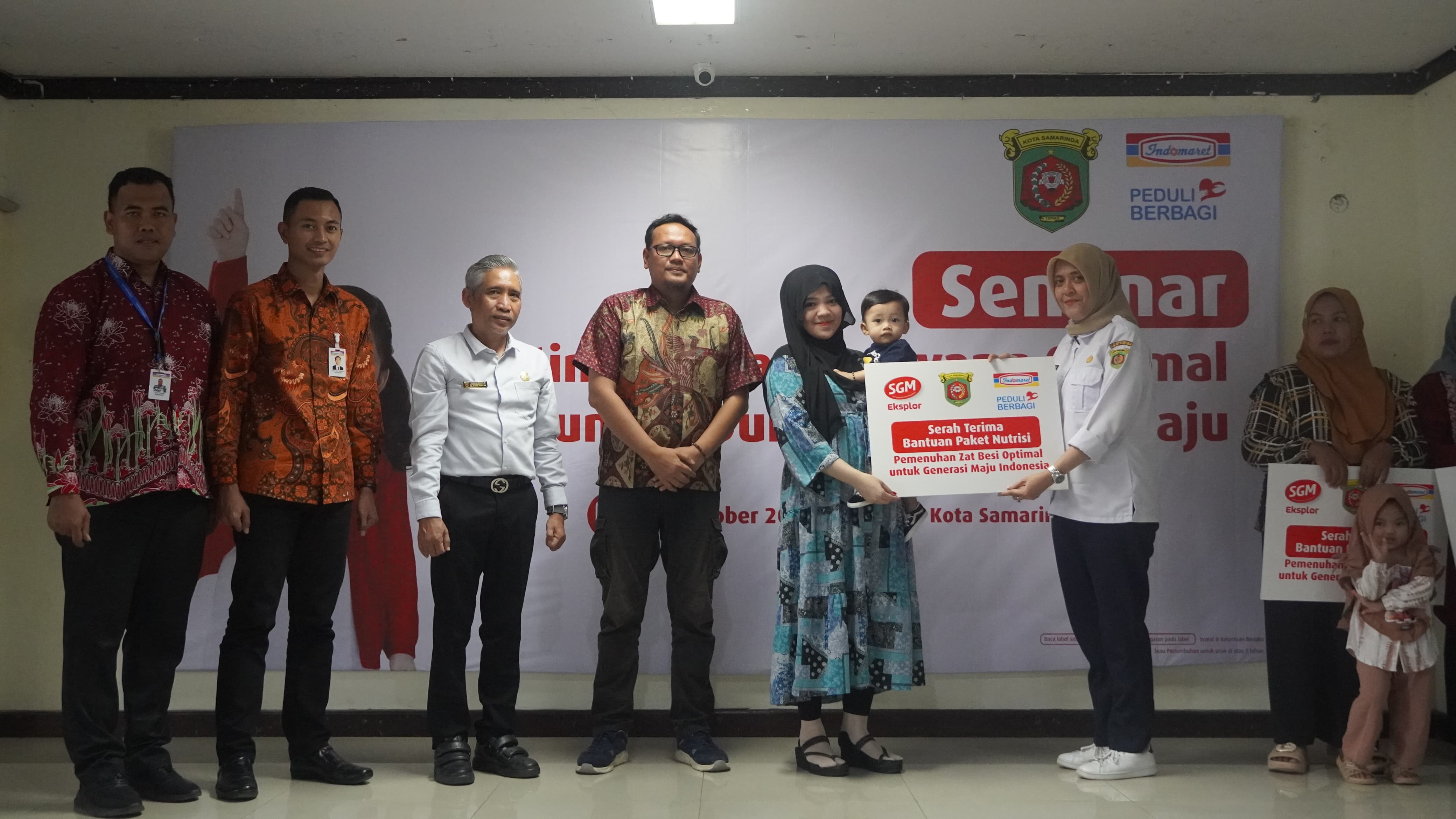 BANTUAN: Kepala Disdag Samarinda Nurrahmani (dua kanan) menyerahkan bantuan paket nutrisi kepada warga.